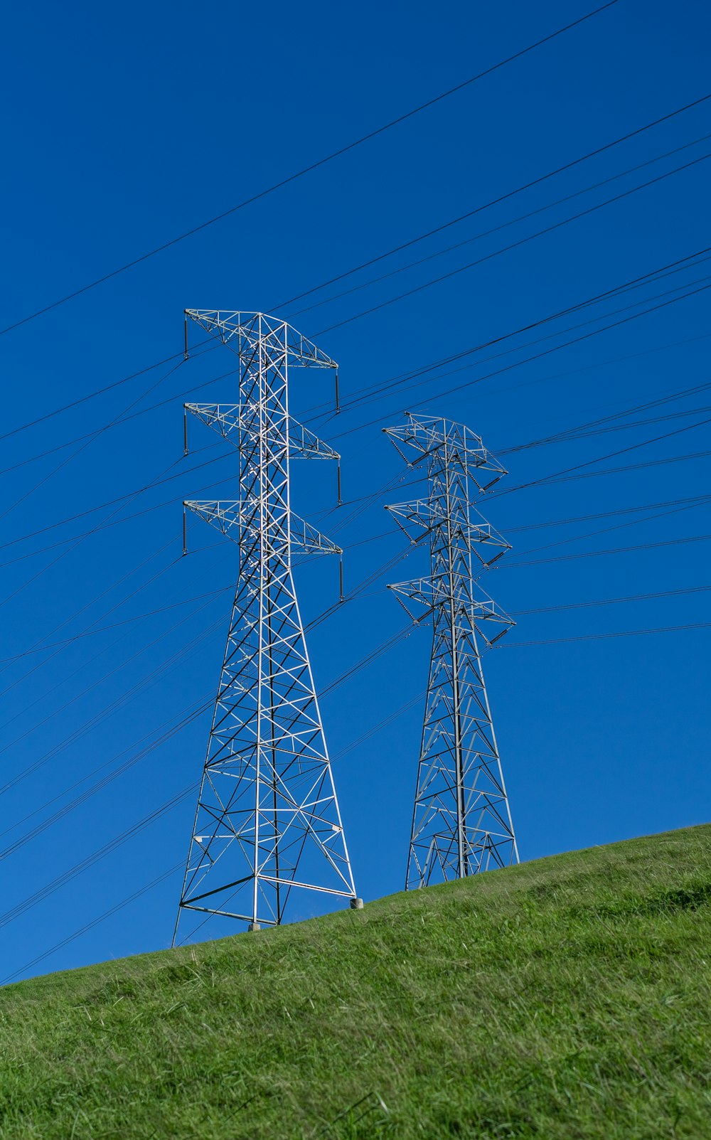 a couple of power lines sitting on top of a lush green hillside