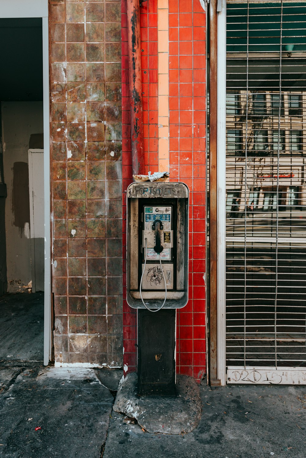 an old pay phone on the side of a building