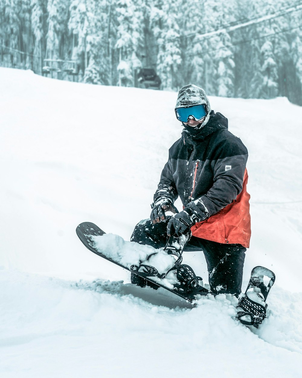 a snowboarder sitting in the snow with his board