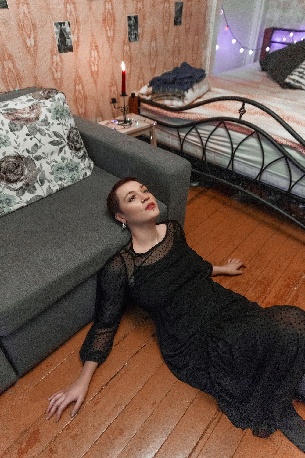 uma mulher deitada no chão ao lado de uma cama