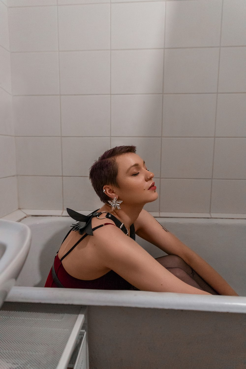 Eine Frau sitzt in einer Badewanne in einem Badezimmer