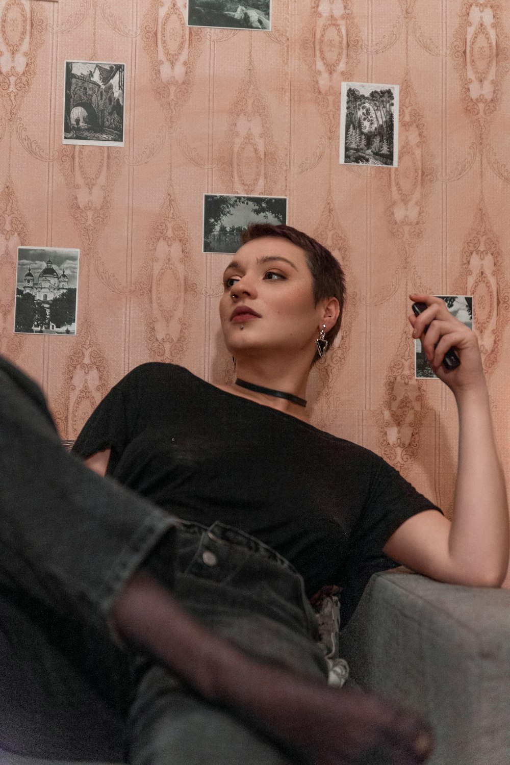 Una mujer sentada en un sofá sosteniendo un cigarrillo