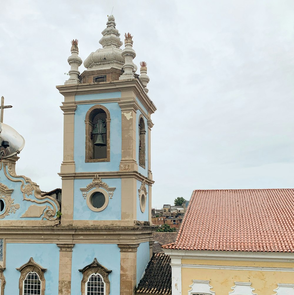 a blue and tan church with a cross on top