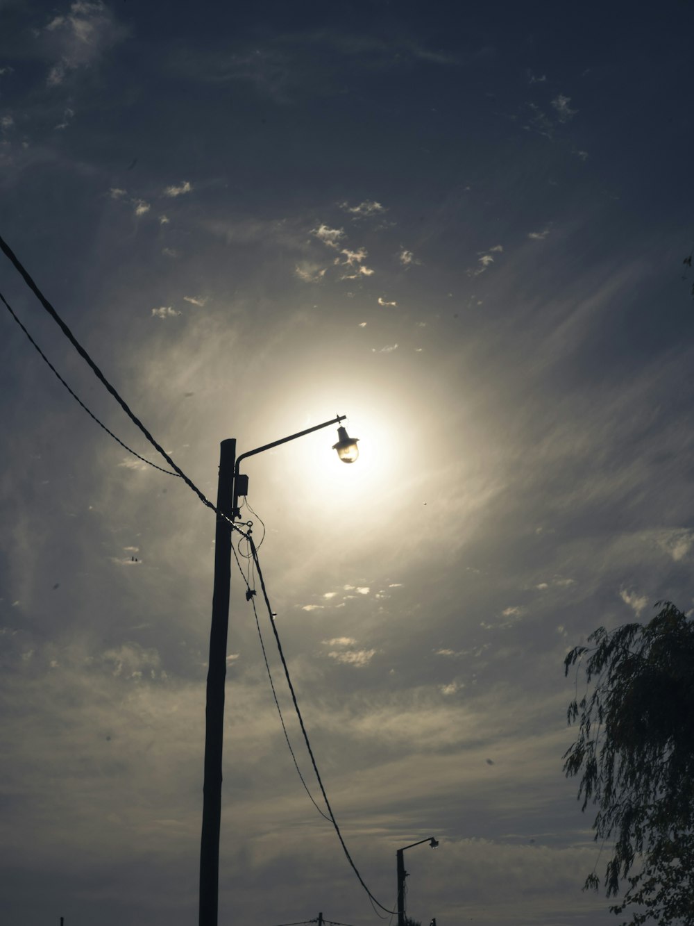 a street light with the sun in the background