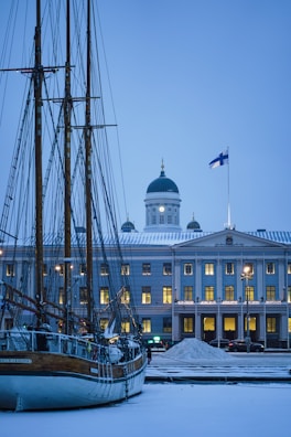 a boat is docked in front of a large building