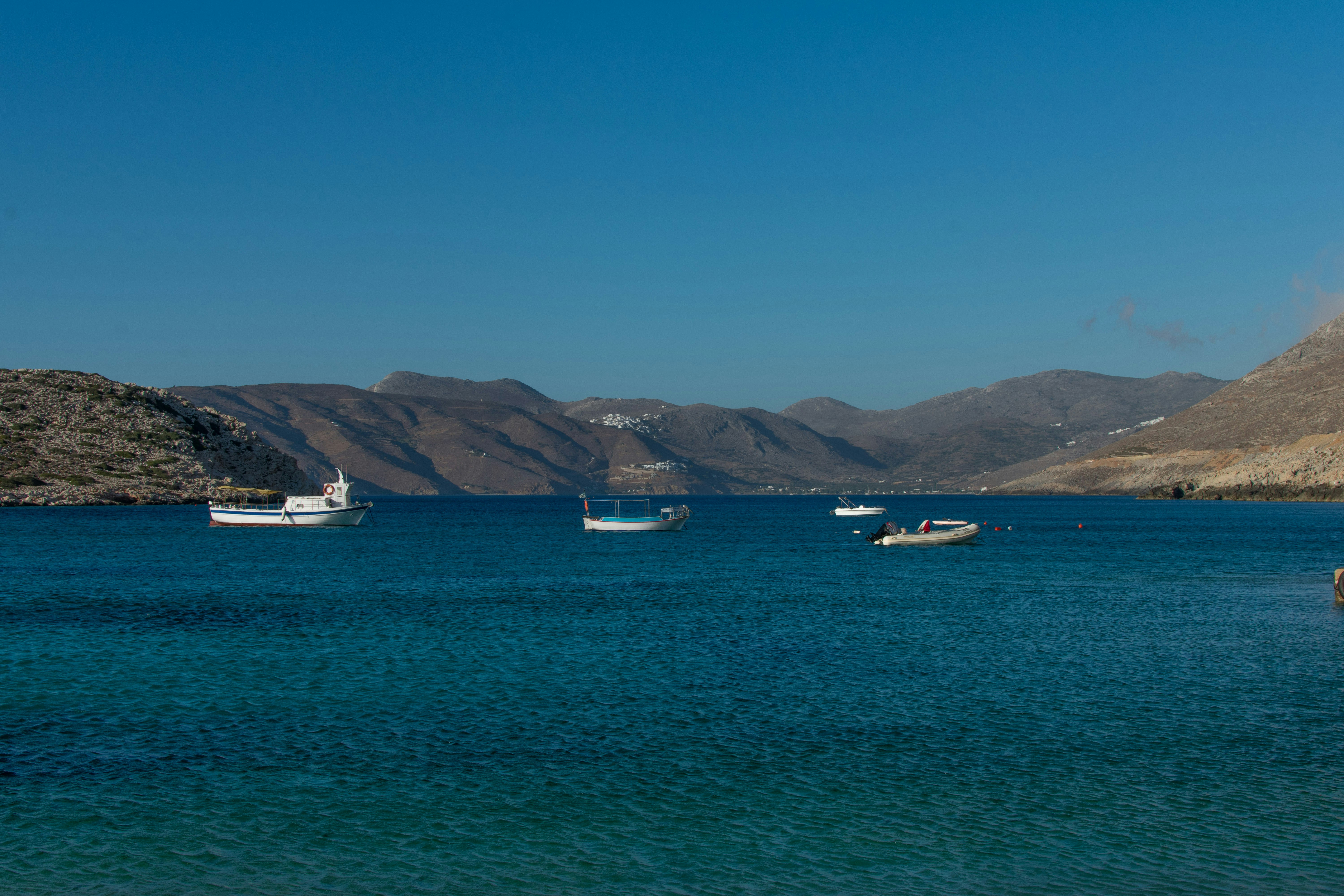 a group of boats floating on top of a large body of water, 