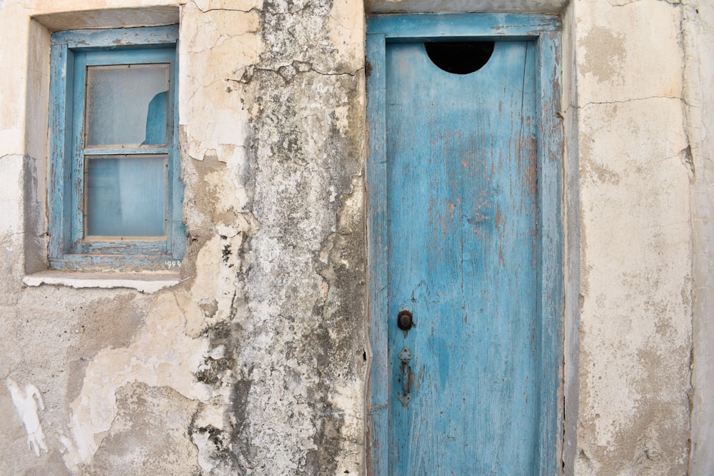 Una puerta y ventana azul en un edificio antiguo