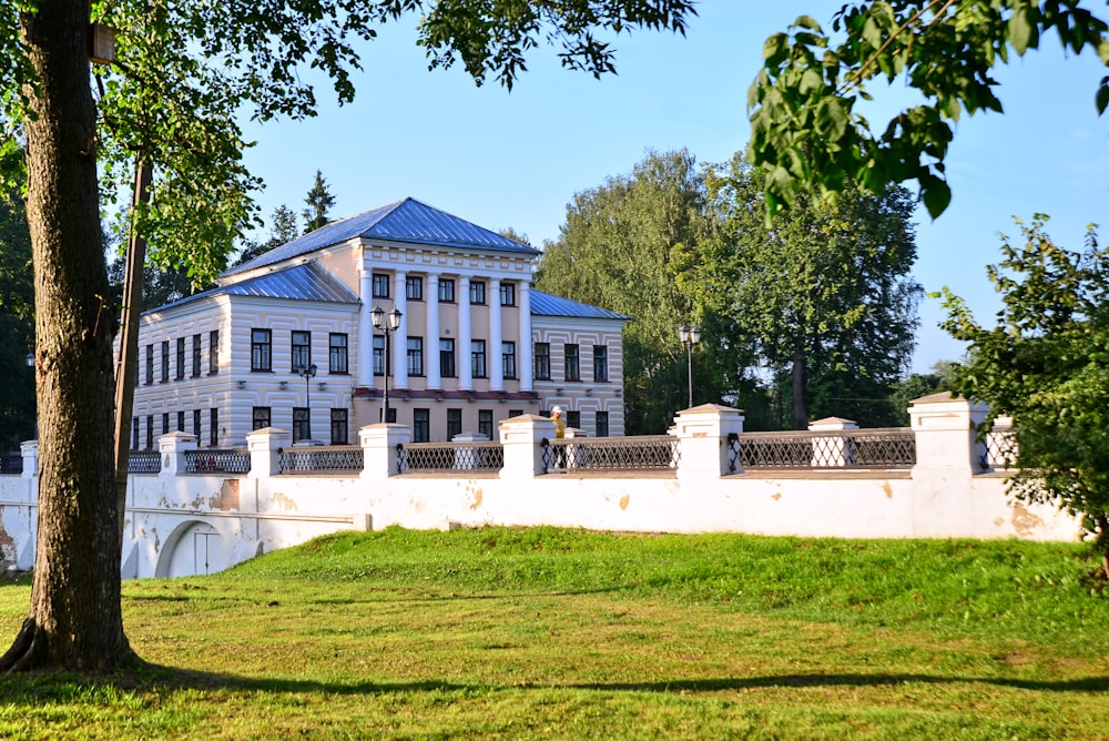 a large white building sitting next to a lush green park