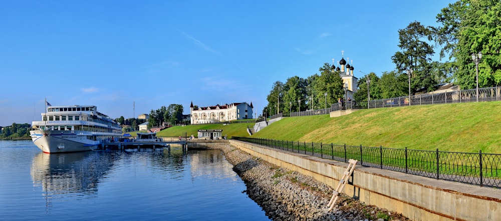 a large boat is docked at the shore of a lake