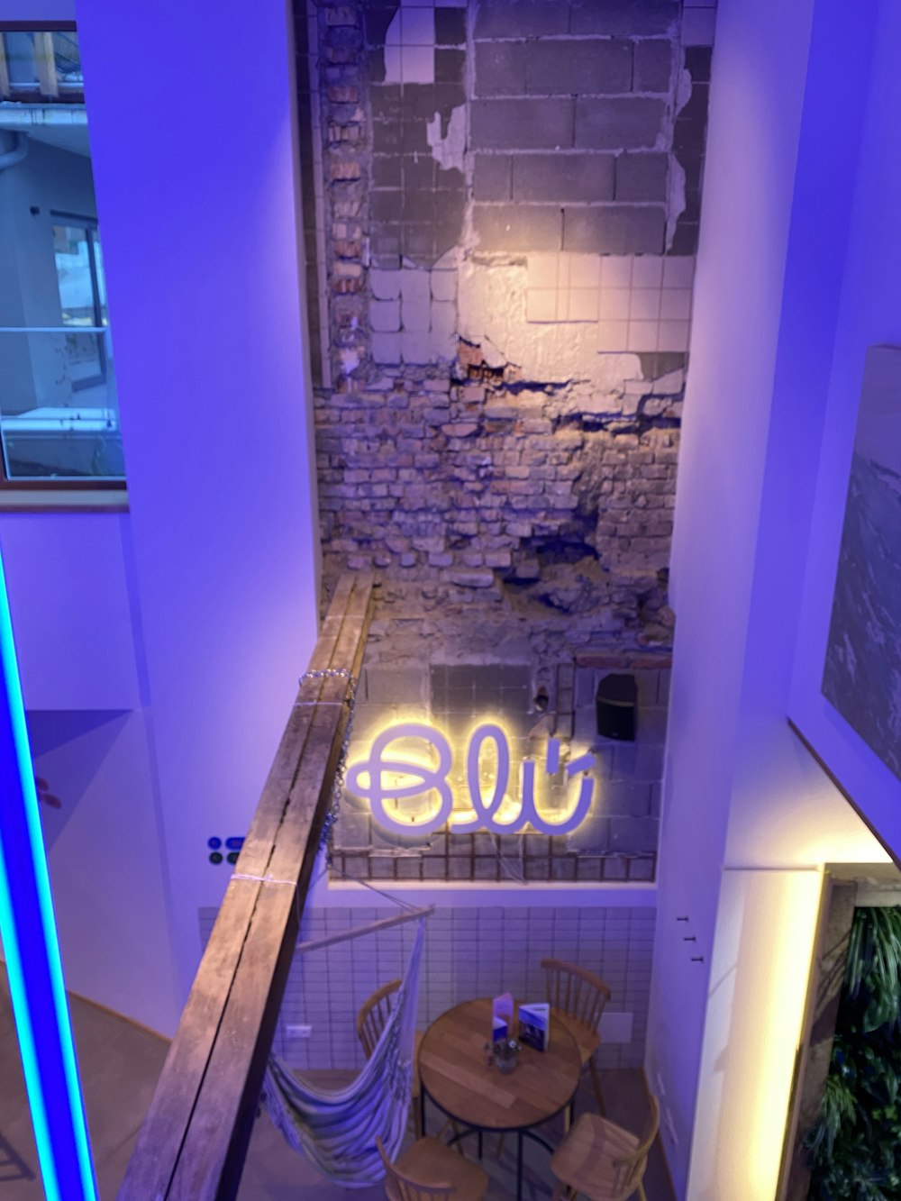 a room with a table and chairs and a neon sign