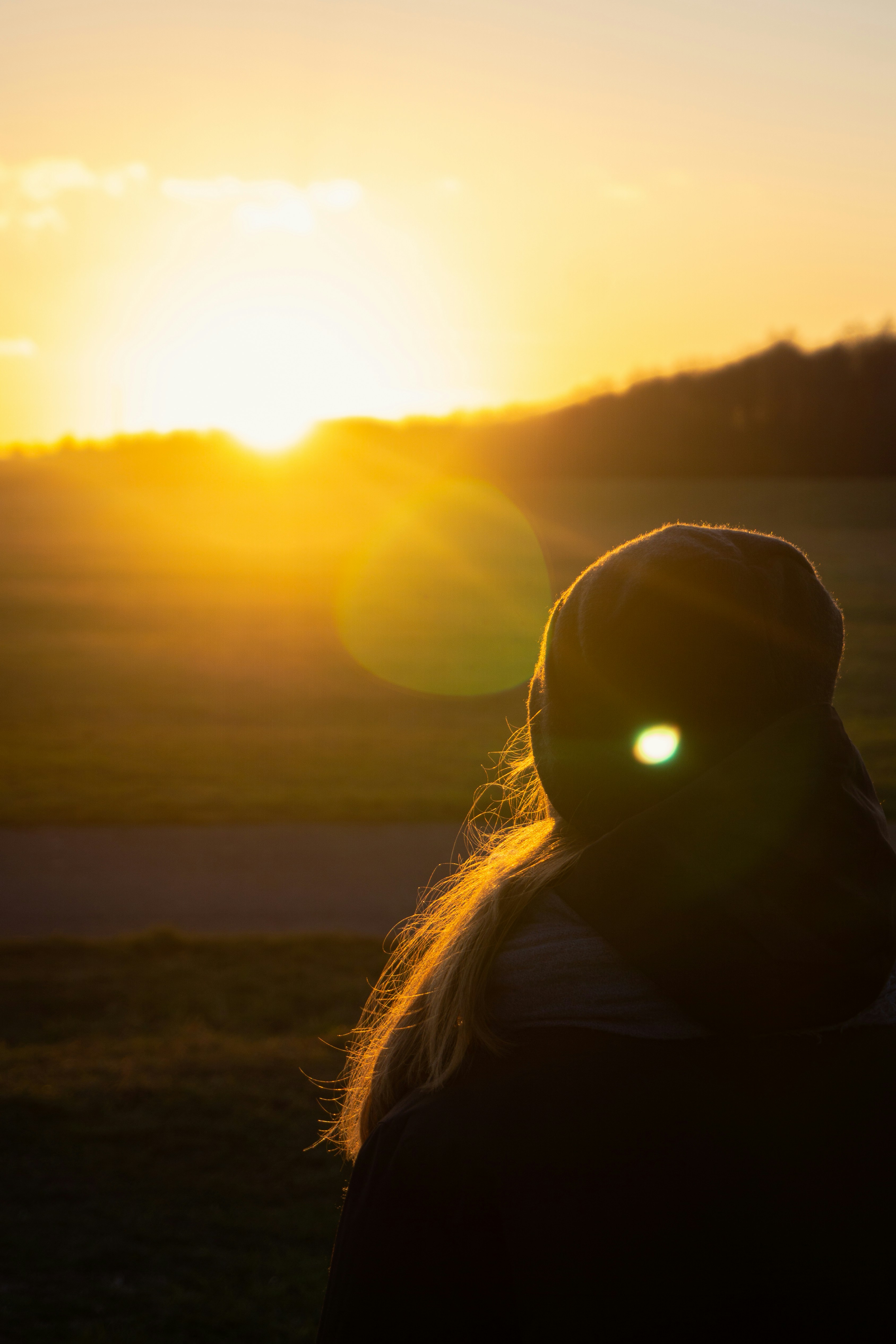 Eine Person, die bei Sonnenuntergang auf einem Feld steht