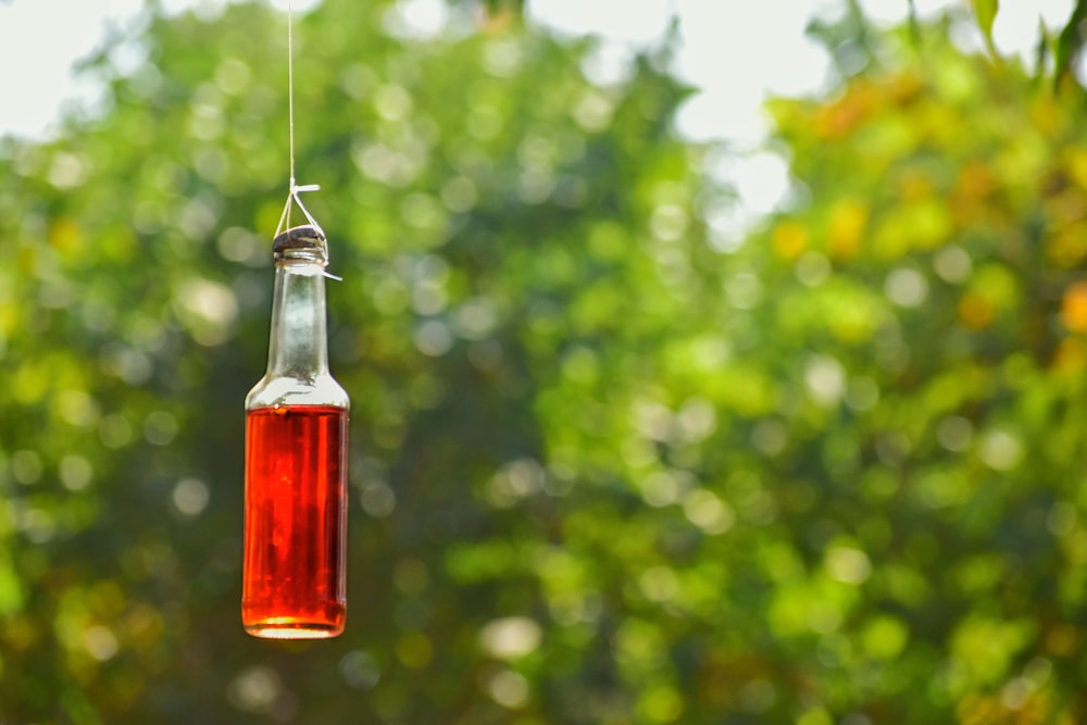 a bottle filled with liquid hanging from a string