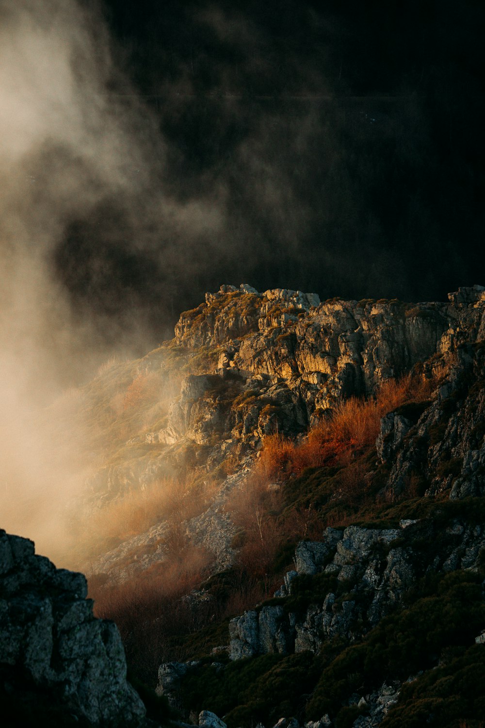 a mountain covered in fog and clouds at night