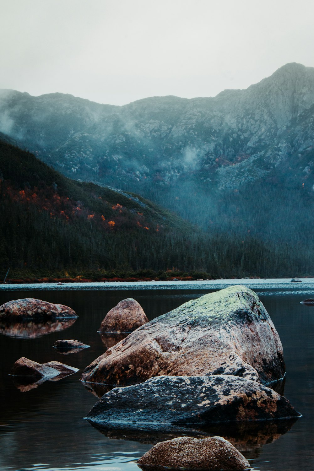 a large rock sitting in the middle of a lake