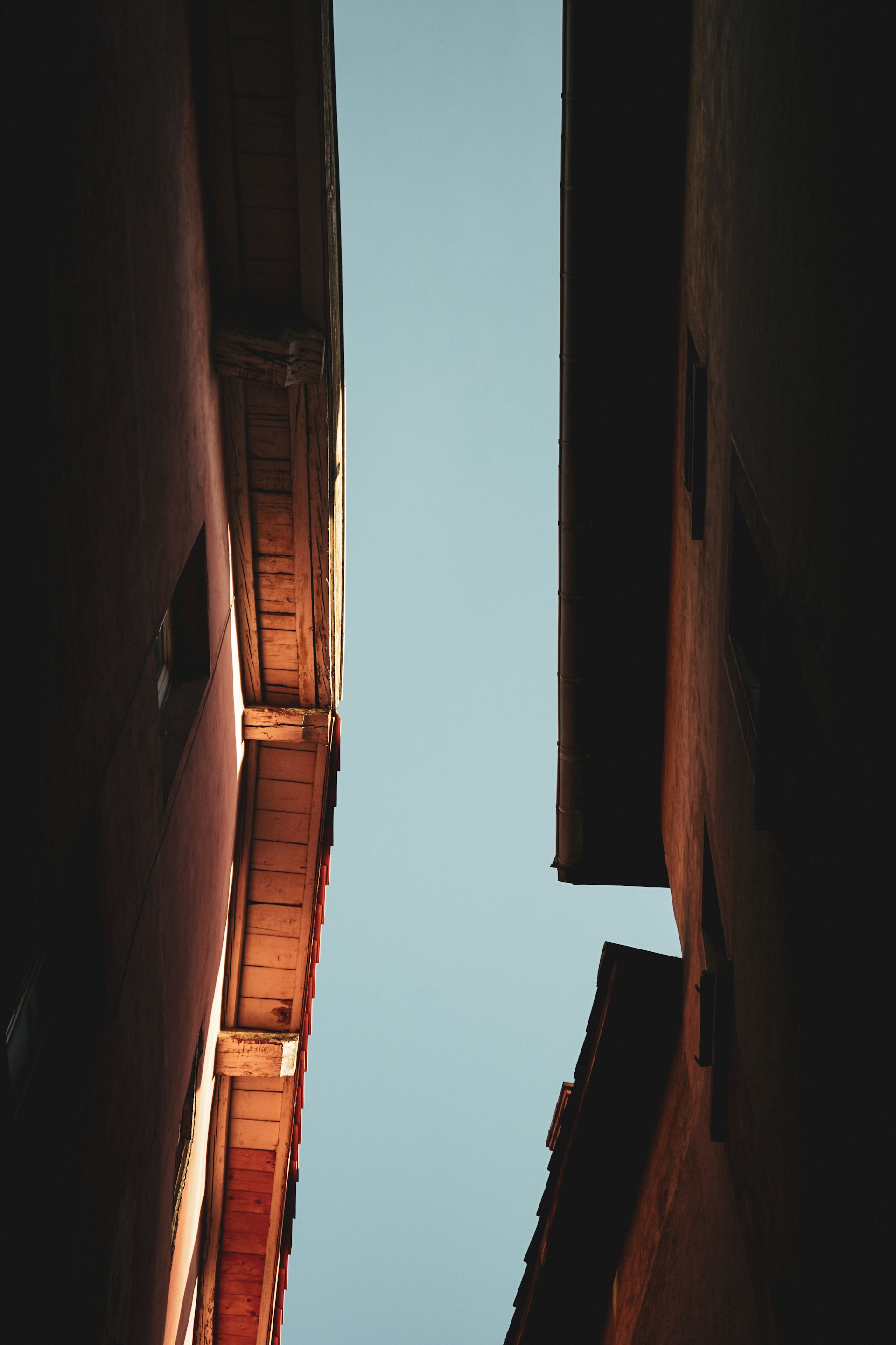 a narrow alley way with two buildings in the background