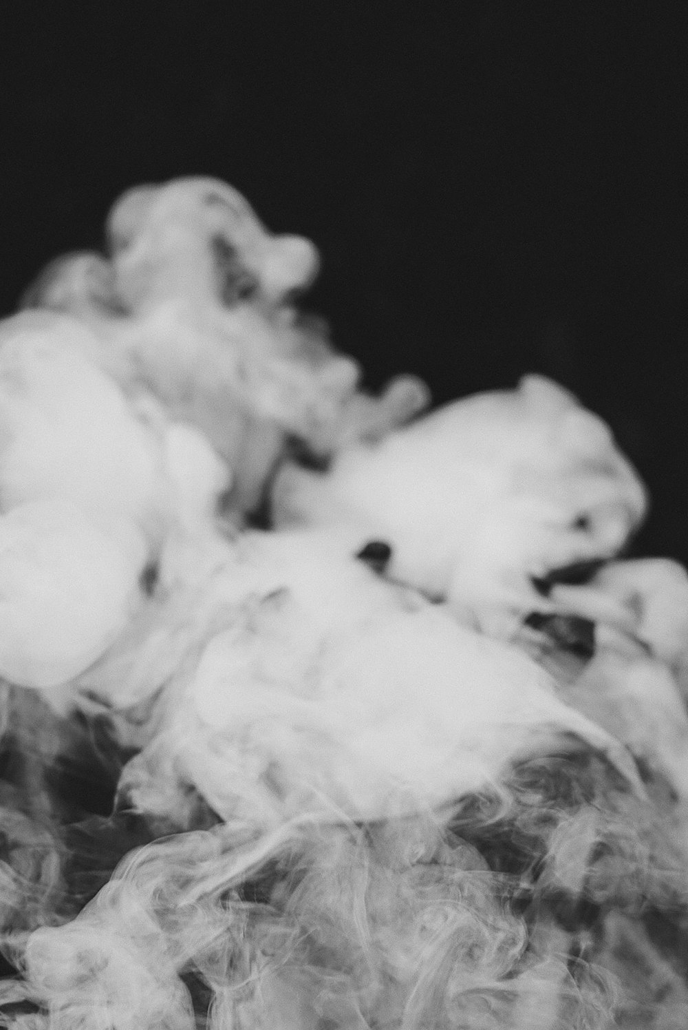 a black and white photo of white smoke