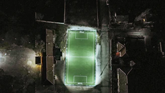 dark-themed football pitch with neon green data overlays and a focused analyst at work