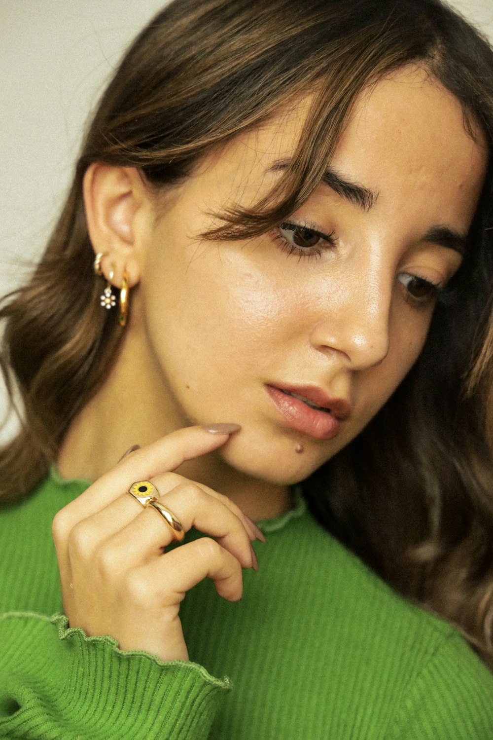 a woman in a green sweater holding a cell phone