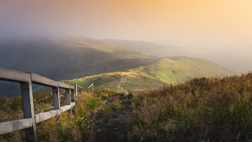 a road going up a hill with mountains in the background