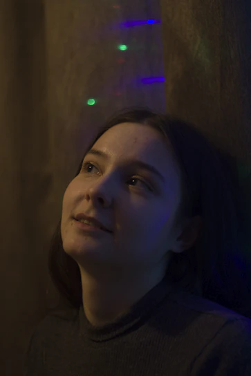 A calm and thoughtful person looking at a dream journal under soft lighting.
