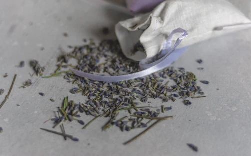 Close-up of a handmade lavender sachet resting on a natural wood surface with soft morning light.