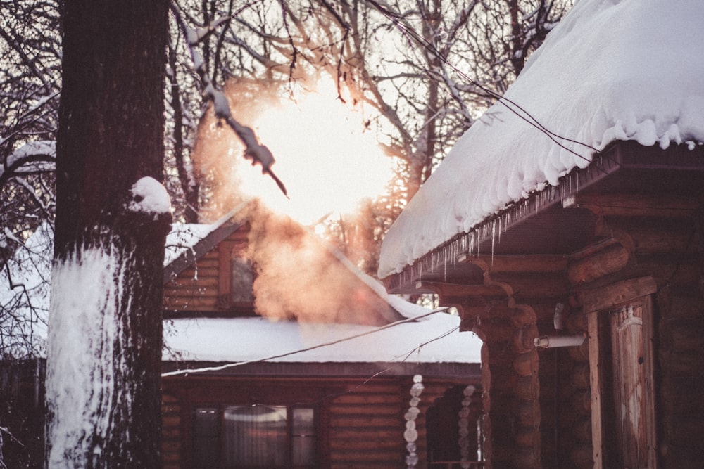 smoke coming out of the chimney of a log cabin