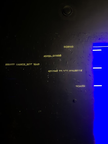 A sleek yellow Upnet logo brightly standing out on a moody dark textured wall.