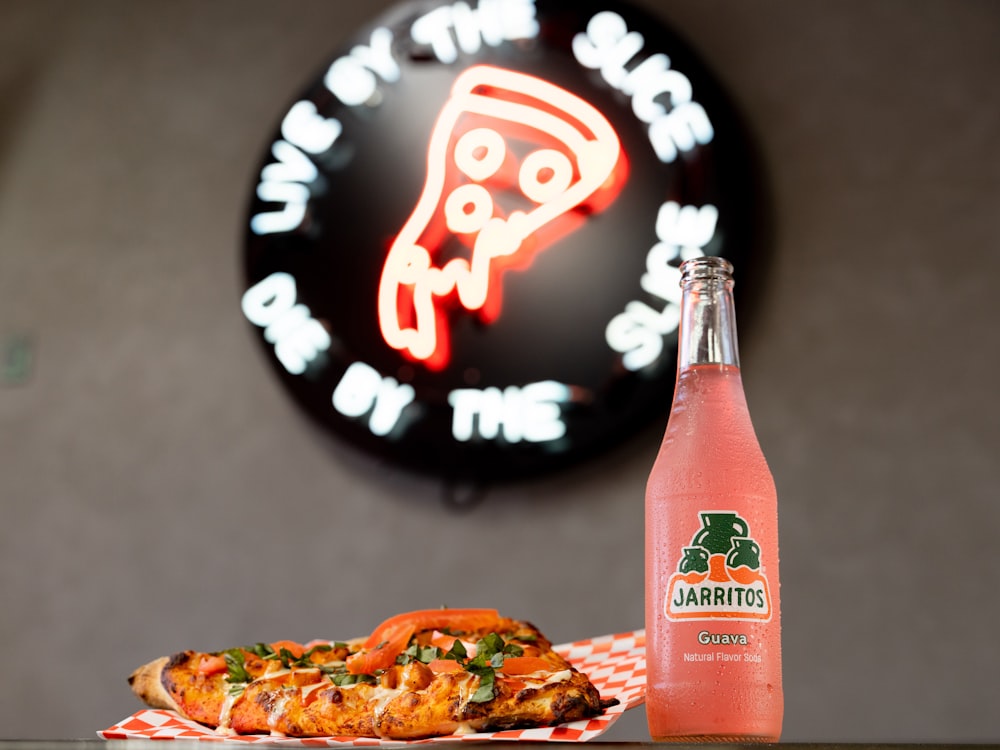 a bottle of beer and a pizza on a table