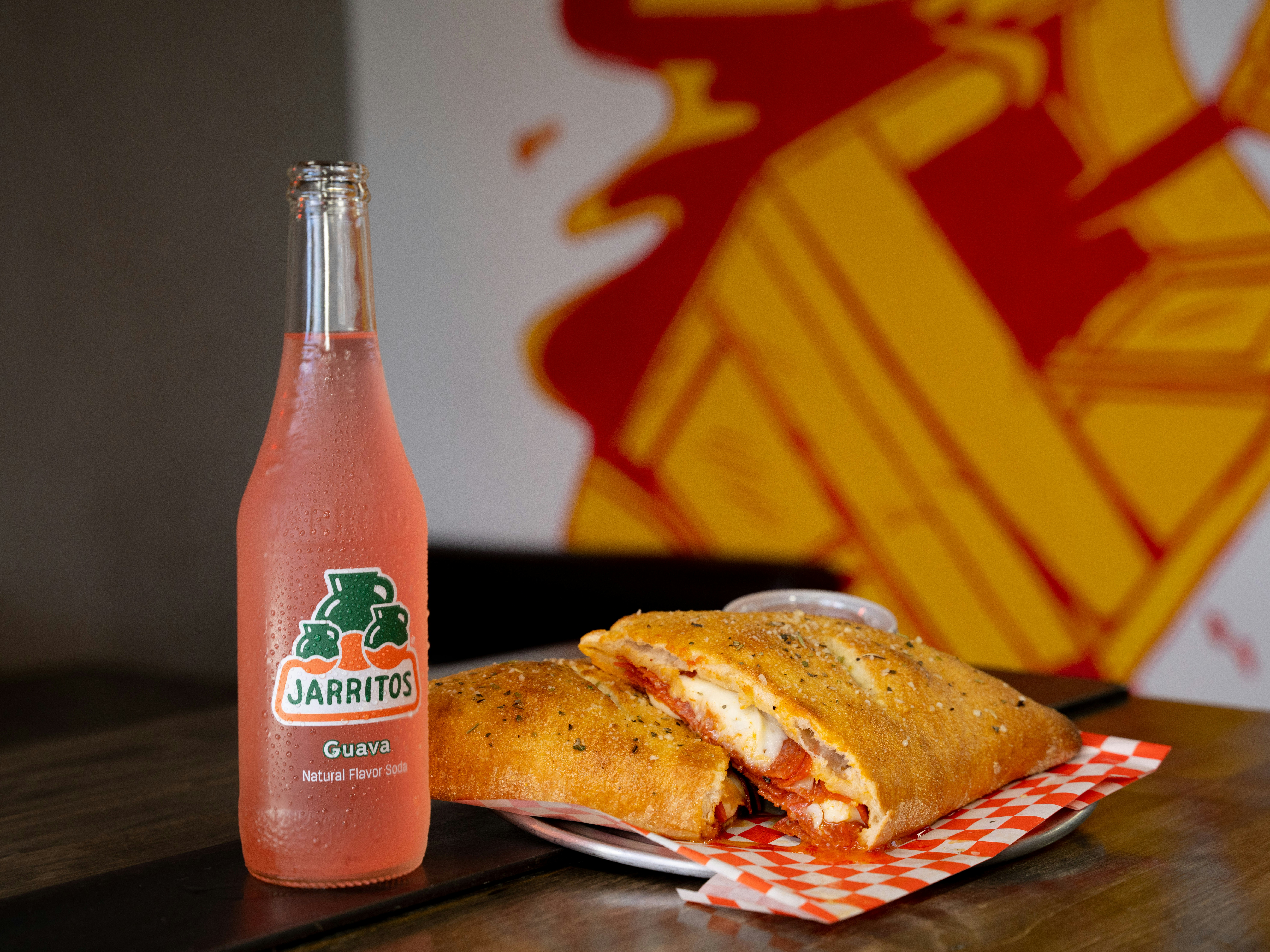 a bottle of juice and a sandwich on a table