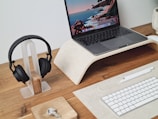 Array of computer accessories including headphones, mouse, and keyboard on a wooden desk.