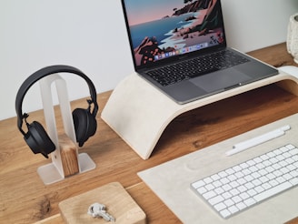 A neat display of various computer peripherals including keyboards, mice, and headphones on a wooden desk.