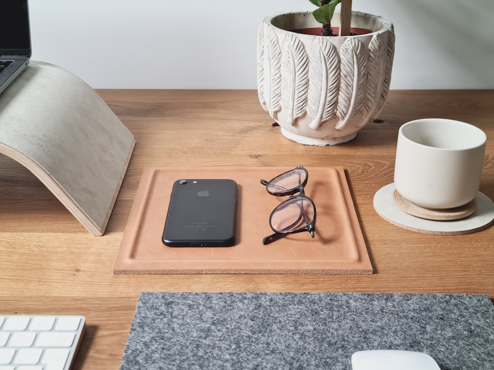 a wooden desk topped with a laptop computer and glasses