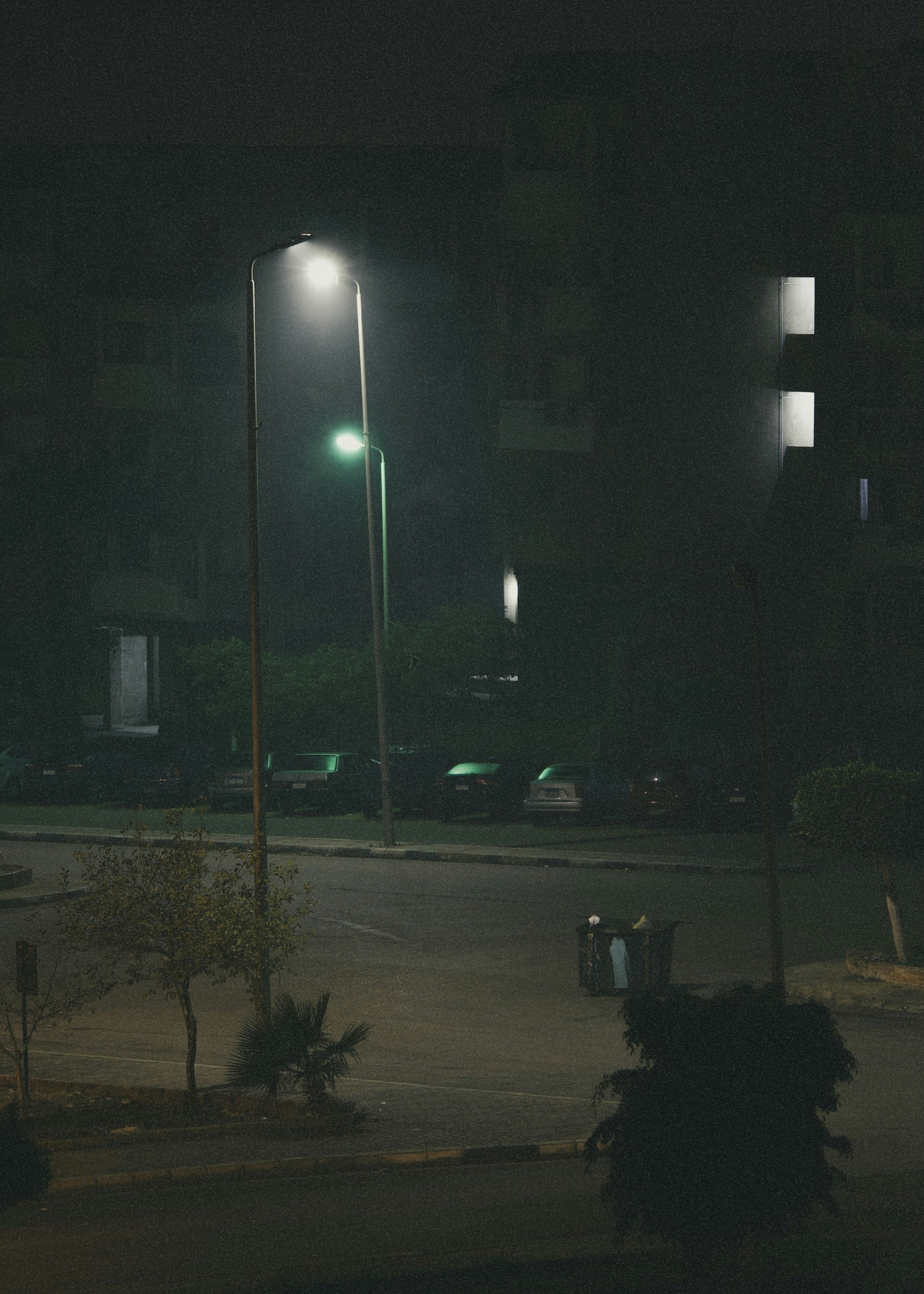 Urban street scene at night with moody low-key lighting and deep shadows