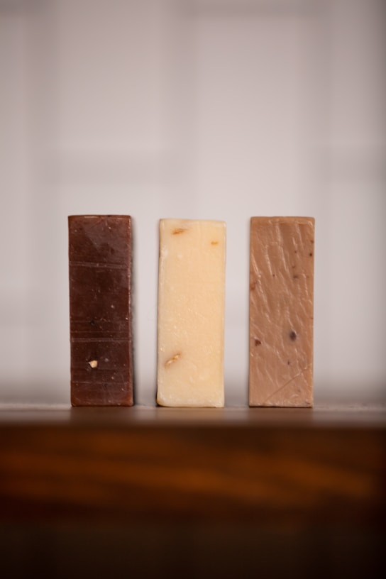 three bars of soap sitting on top of a wooden table