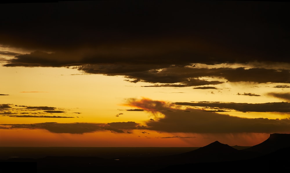 a plane flying in the sky at sunset