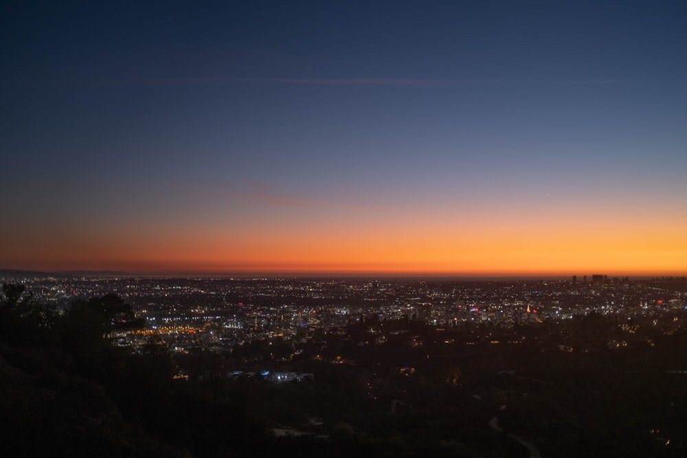 a view of a city at sunset from a hill