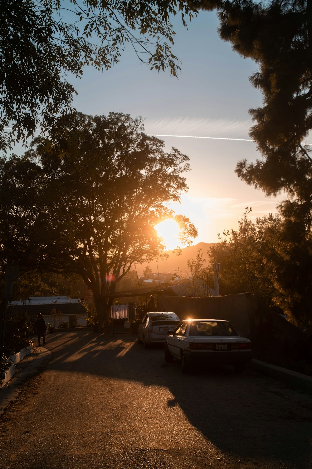 cars parked on the side of the road at sunset