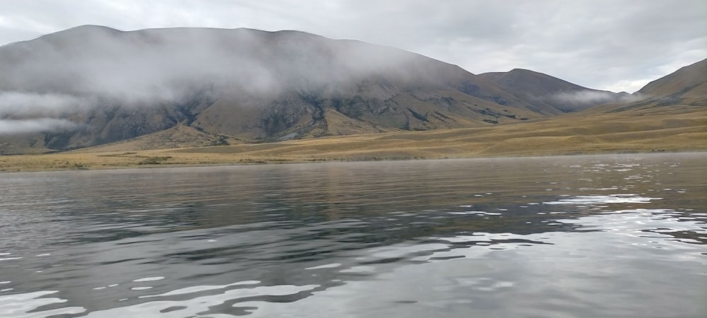 a body of water with a mountain in the background