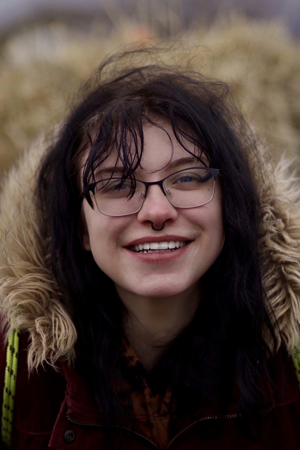 a woman wearing glasses and a red jacket