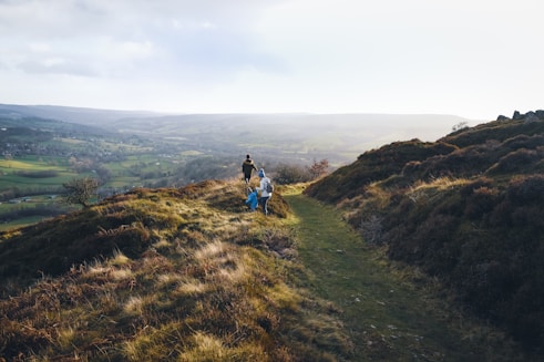 a couple of people that are standing on a hill