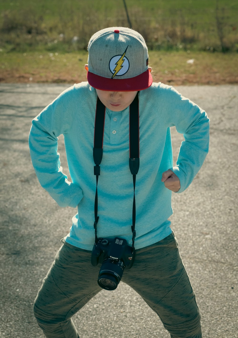 a young boy wearing a hat and holding a camera