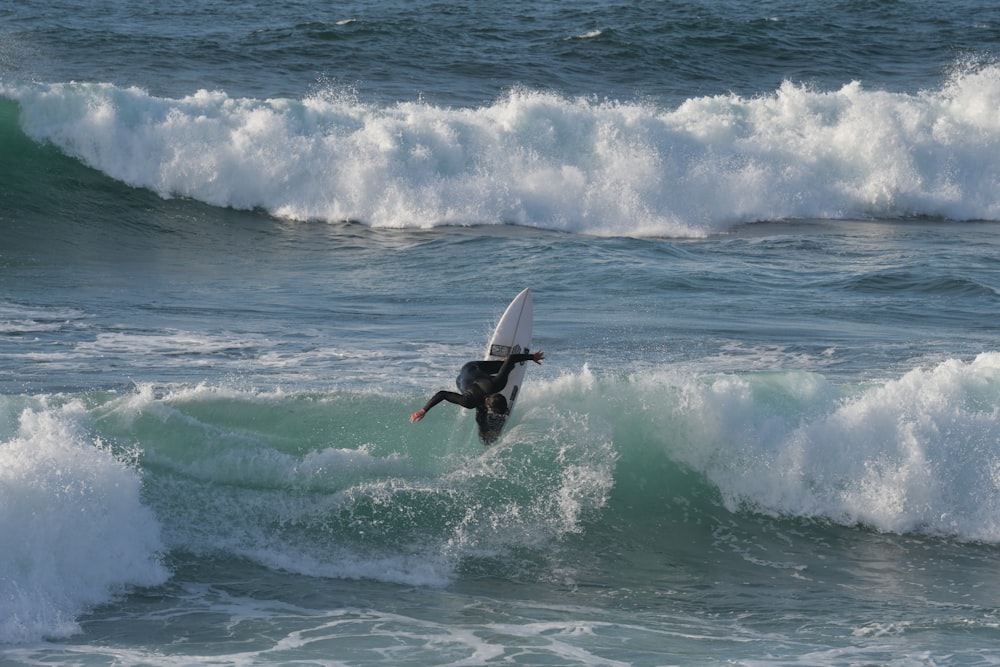 a man riding a wave on top of a surfboard