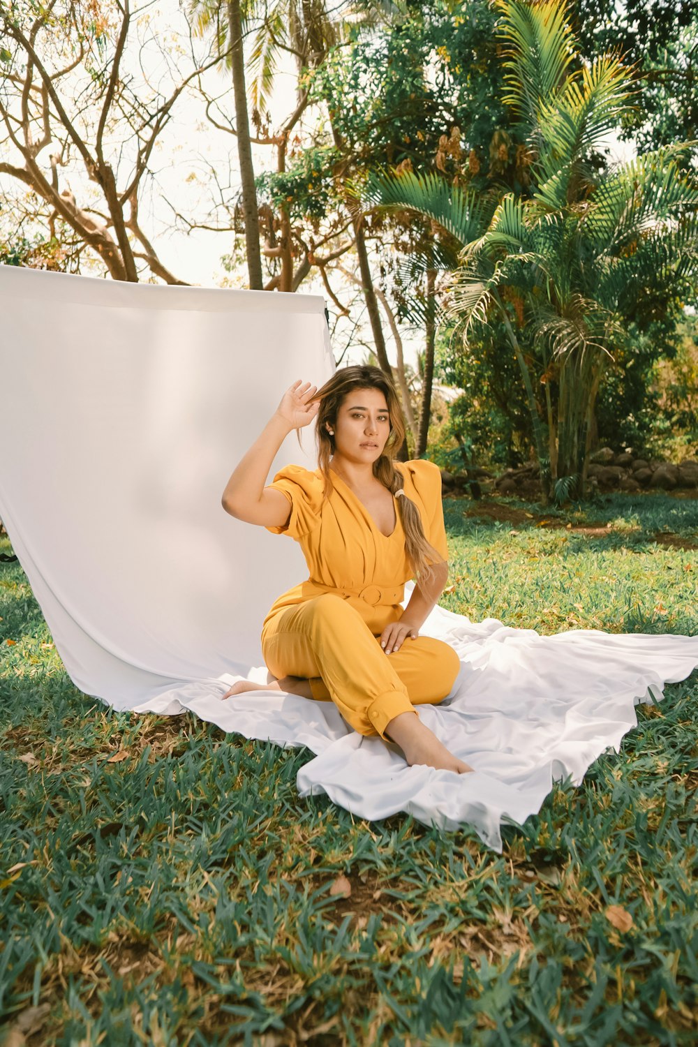 a woman sitting on a blanket in the grass