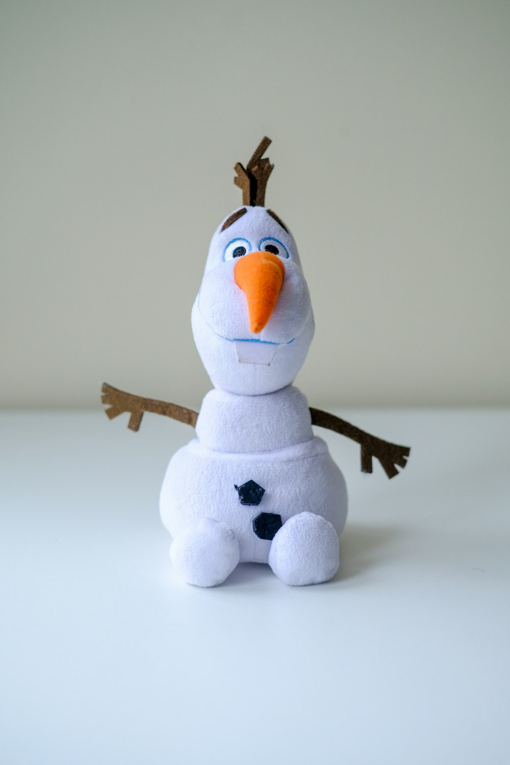 a stuffed snowman sitting on top of a white table