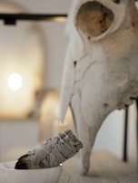 Smoke rising from a ceremonial smudge bowl surrounded by colorful blankets.
