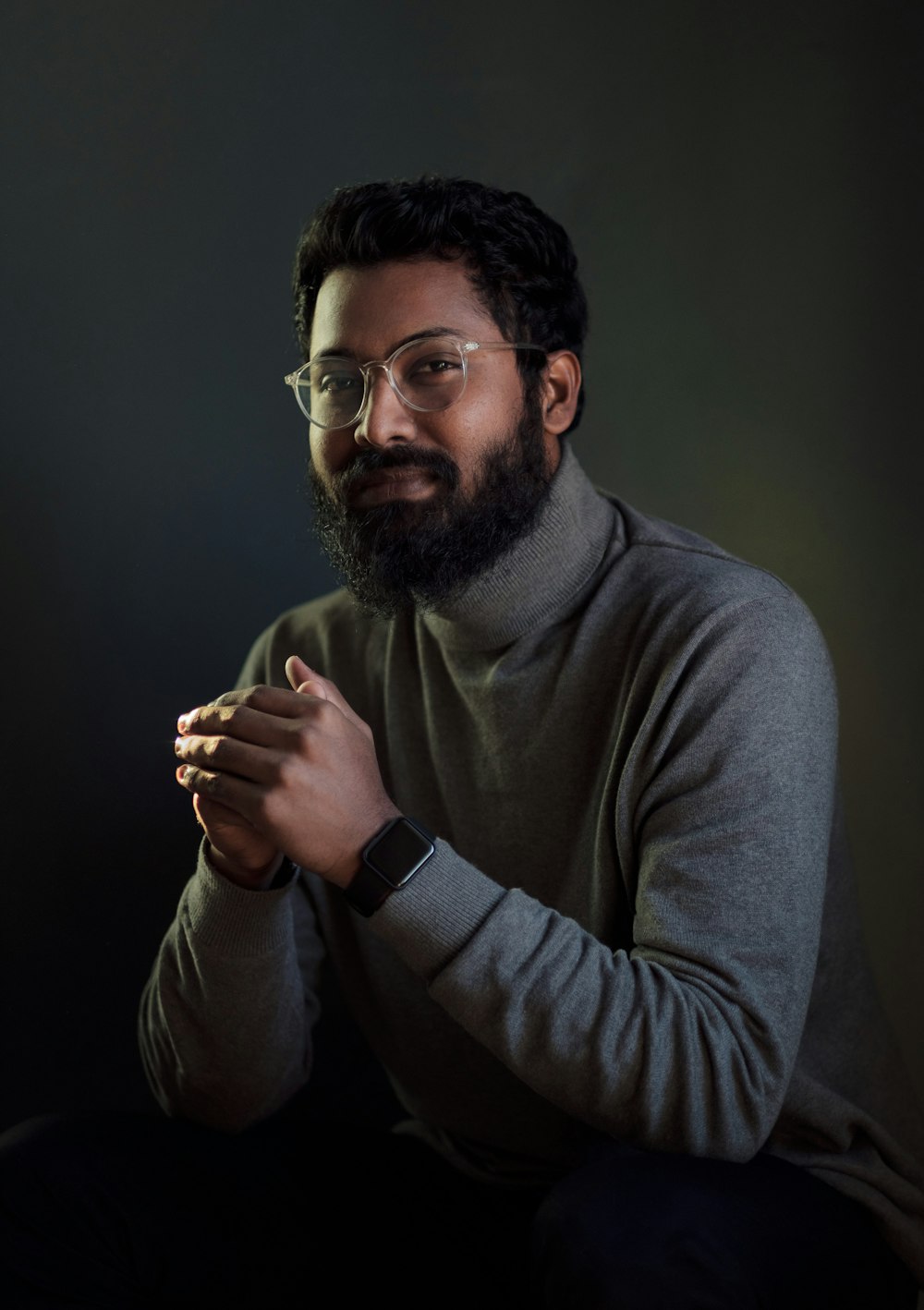 a man with a beard and glasses holding a cigarette