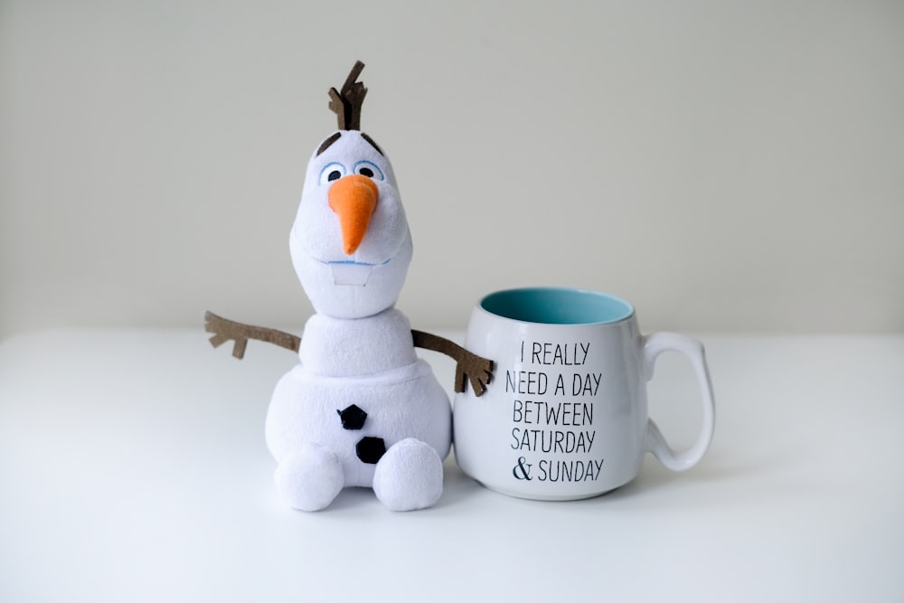 a coffee mug with a stuffed animal next to it