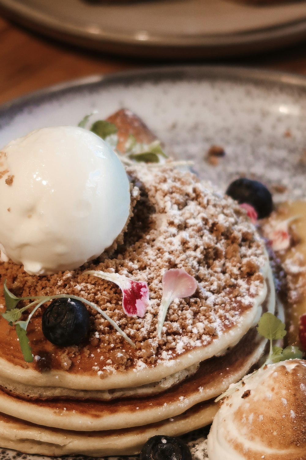 a stack of pancakes topped with fruit and ice cream