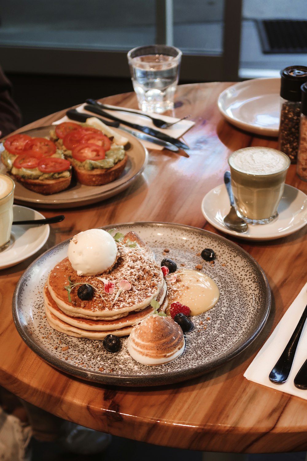 a wooden table topped with plates of food