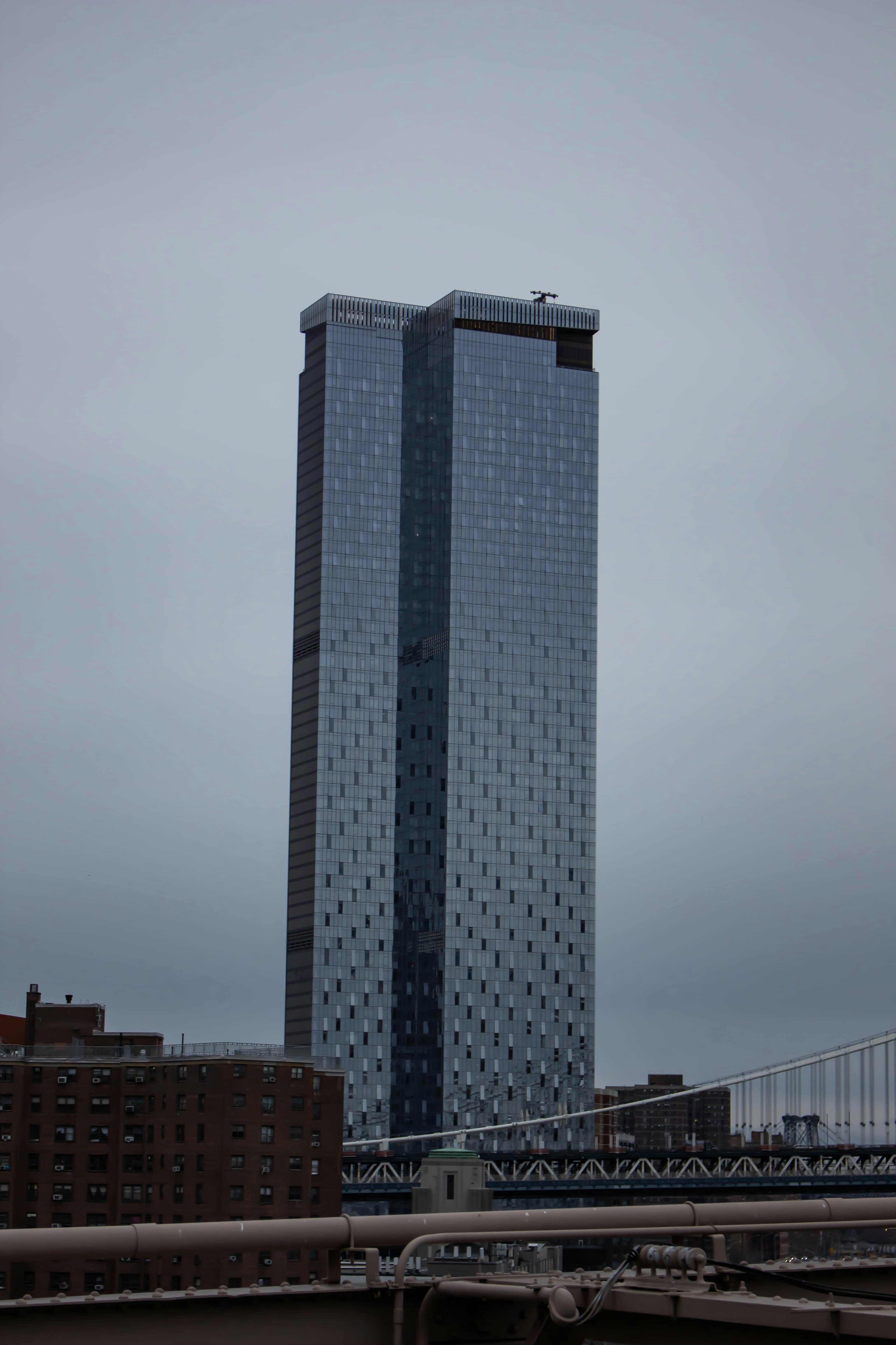 Un edificio muy alto sentado al lado de un puente